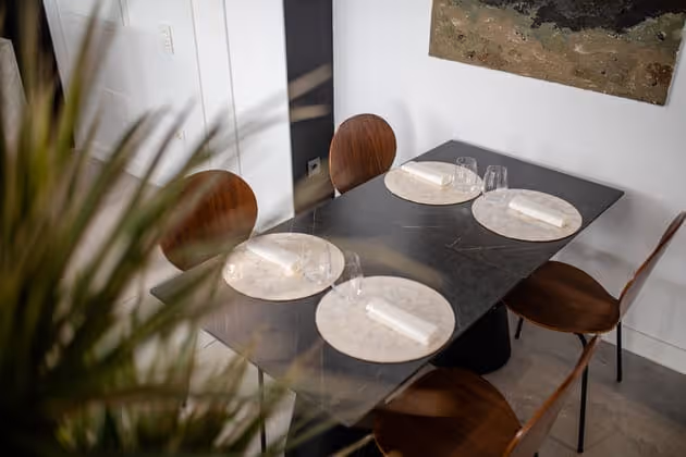 Mesa vestida con vajilla junto a las plantas de la sala